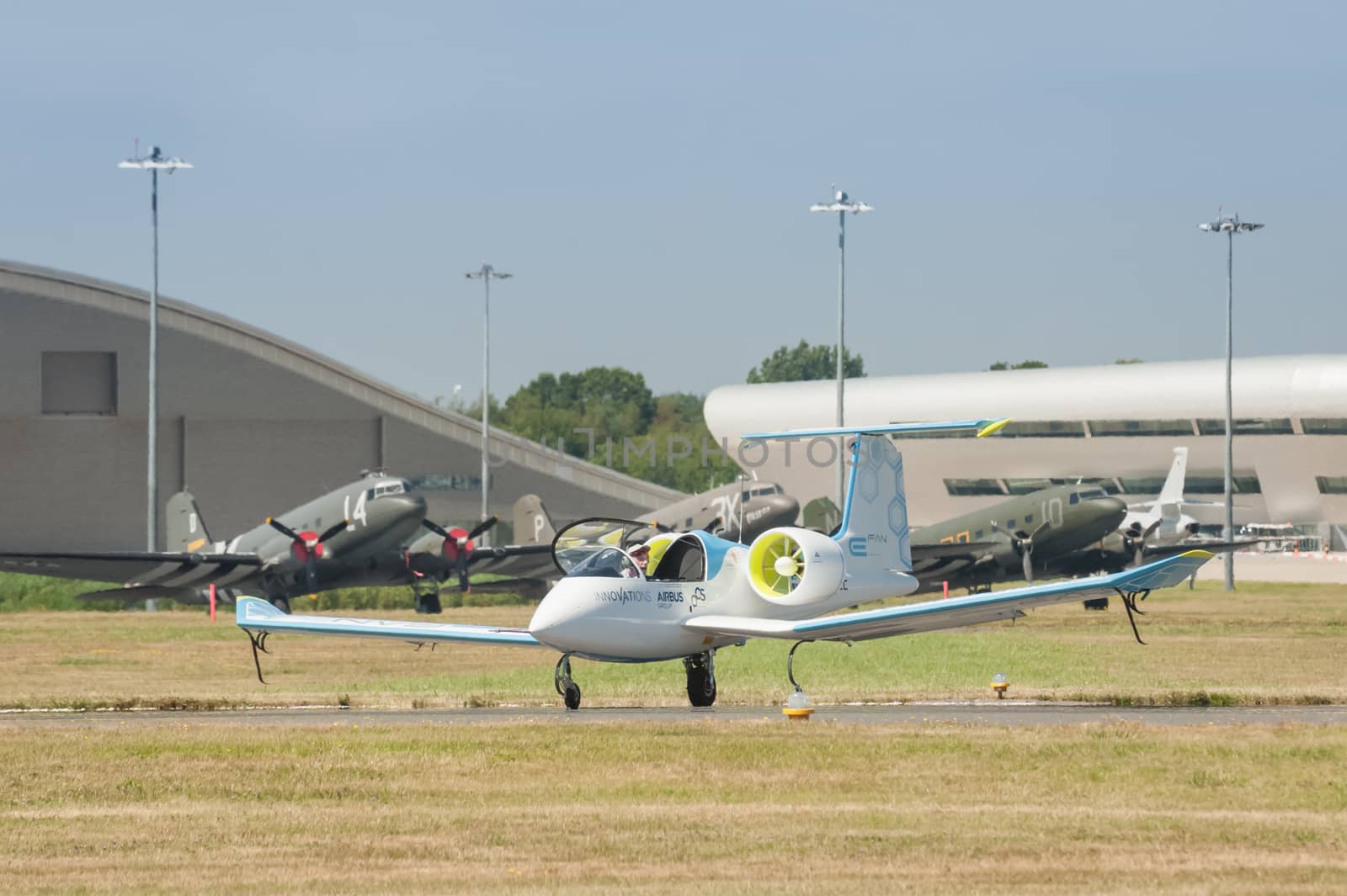 Farnborough, UK - July 18, 2014: The E-Fan, an all electric aircraft developed by Airbus, sharing the taxiway with vintage DC-3 Dakota aircraft at the Farnborough airshow, UK