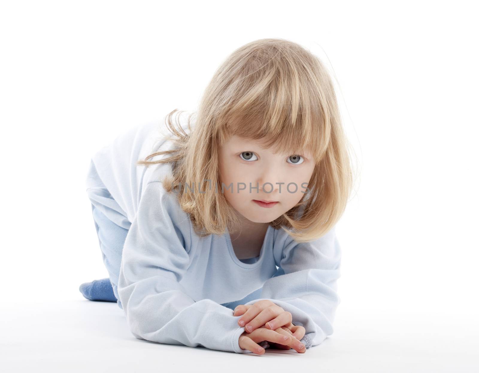 boy with long blond hair on the floor, looking at camera - isolated on white