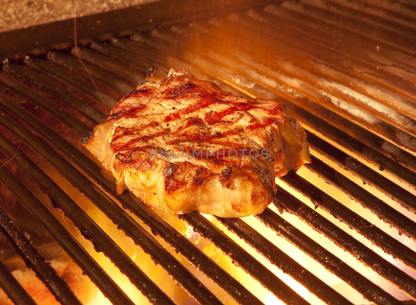 indoor restaurant wooden grill with flames and a big steak