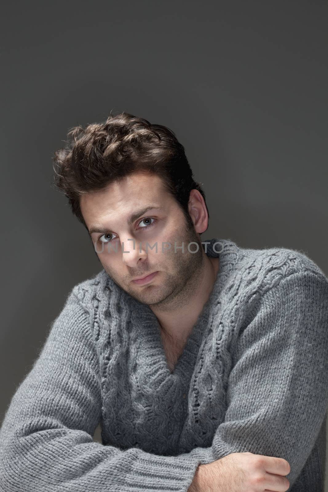 portrait of a man in a sweater looking at camera - isolated on gray