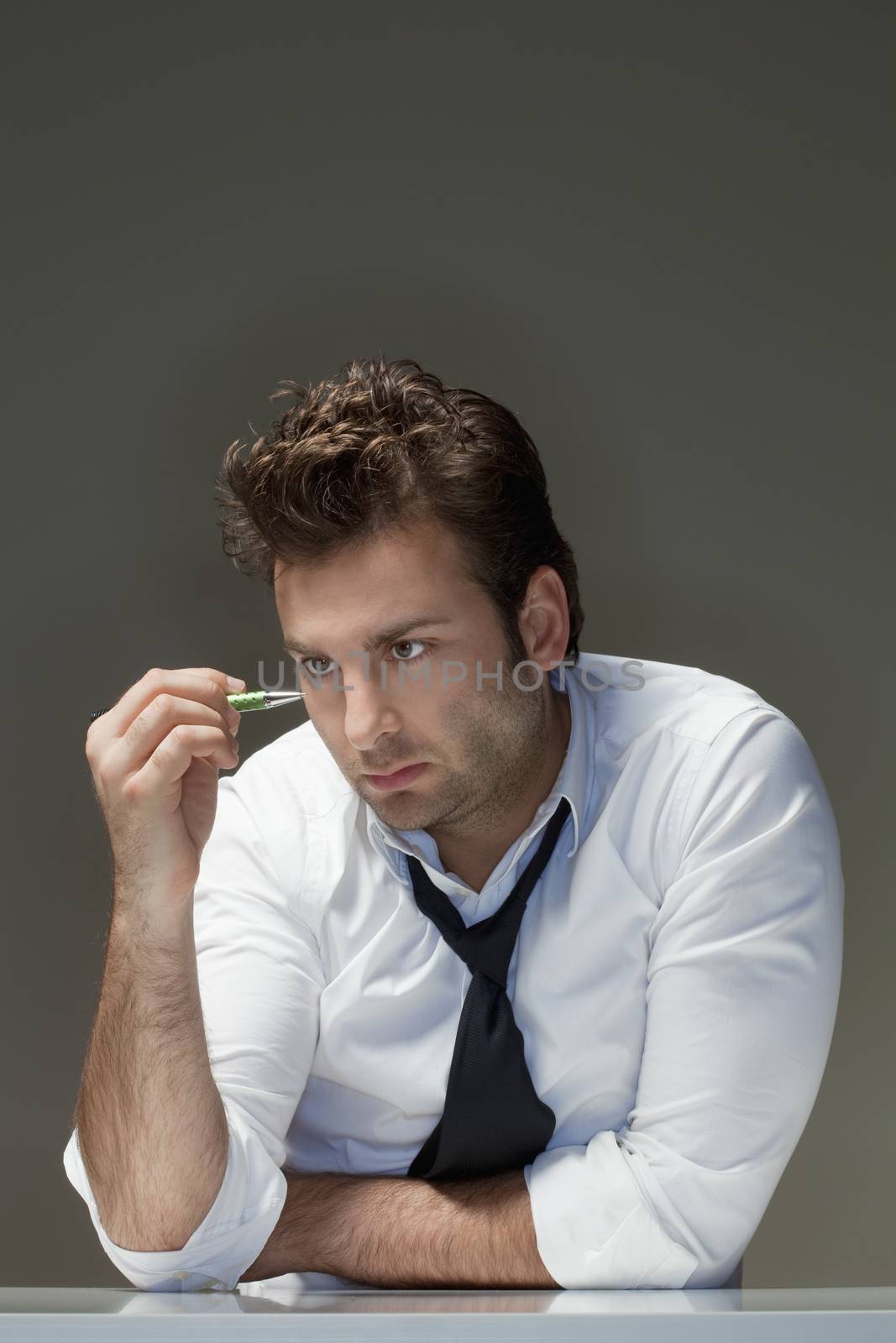 businessman in white shirt looking at pen - isolated on gray