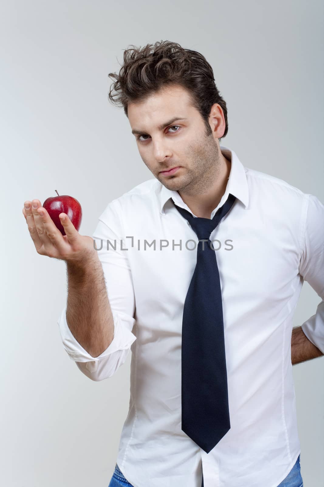 man in white shirt and tie holding red apple looking - isolated on gray