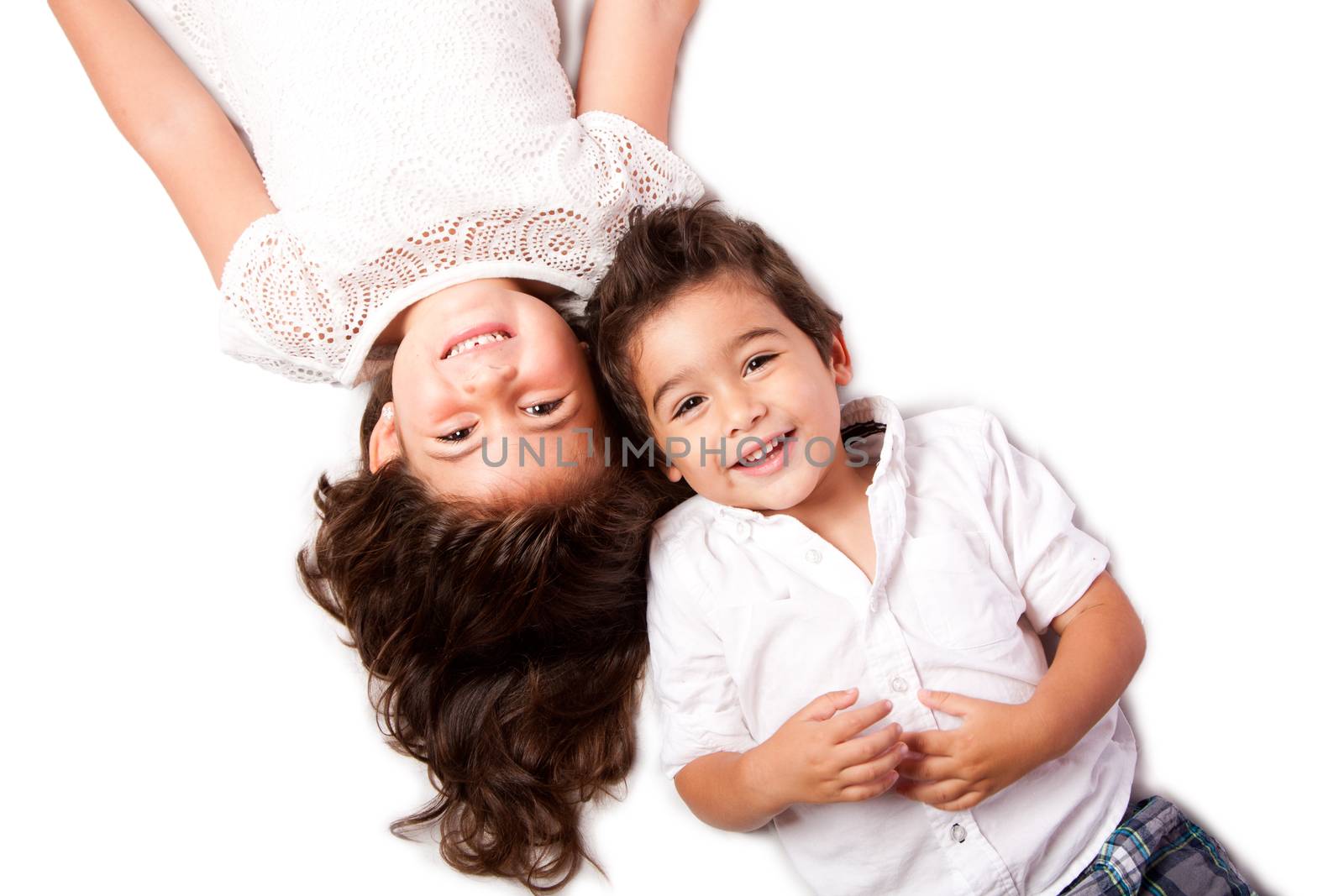 Beautiful happy smiling cute family siblings brother sister laying together on white.