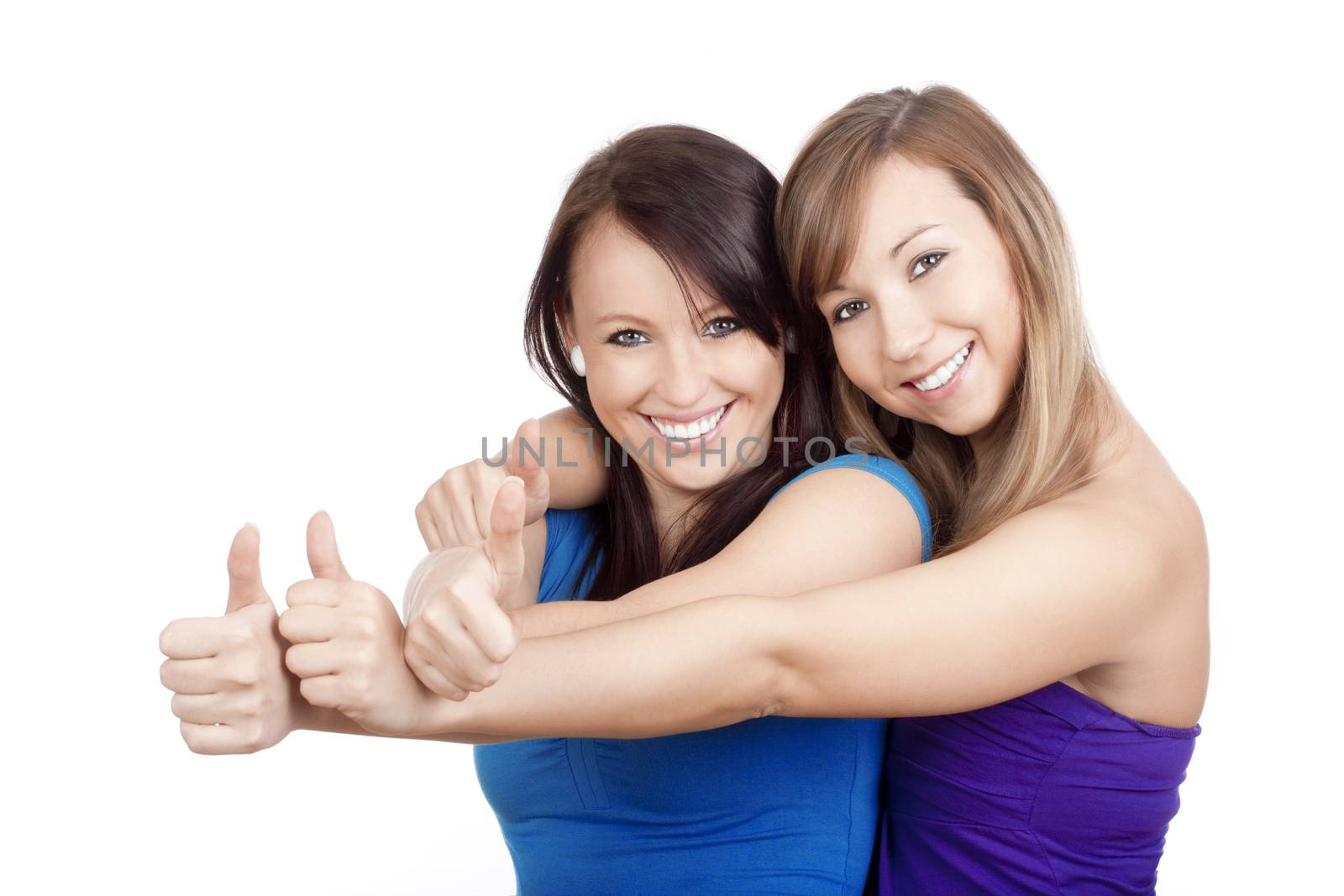 two young women showing thumbs up, smiling - isolated on white