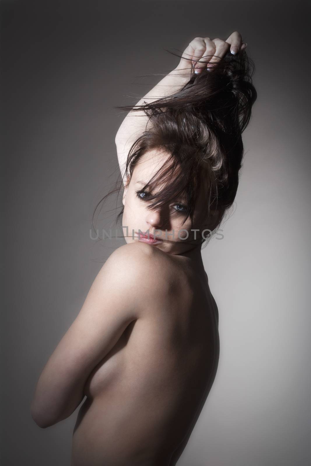 beautiful nude woman with dark hair standing - isolated on gray