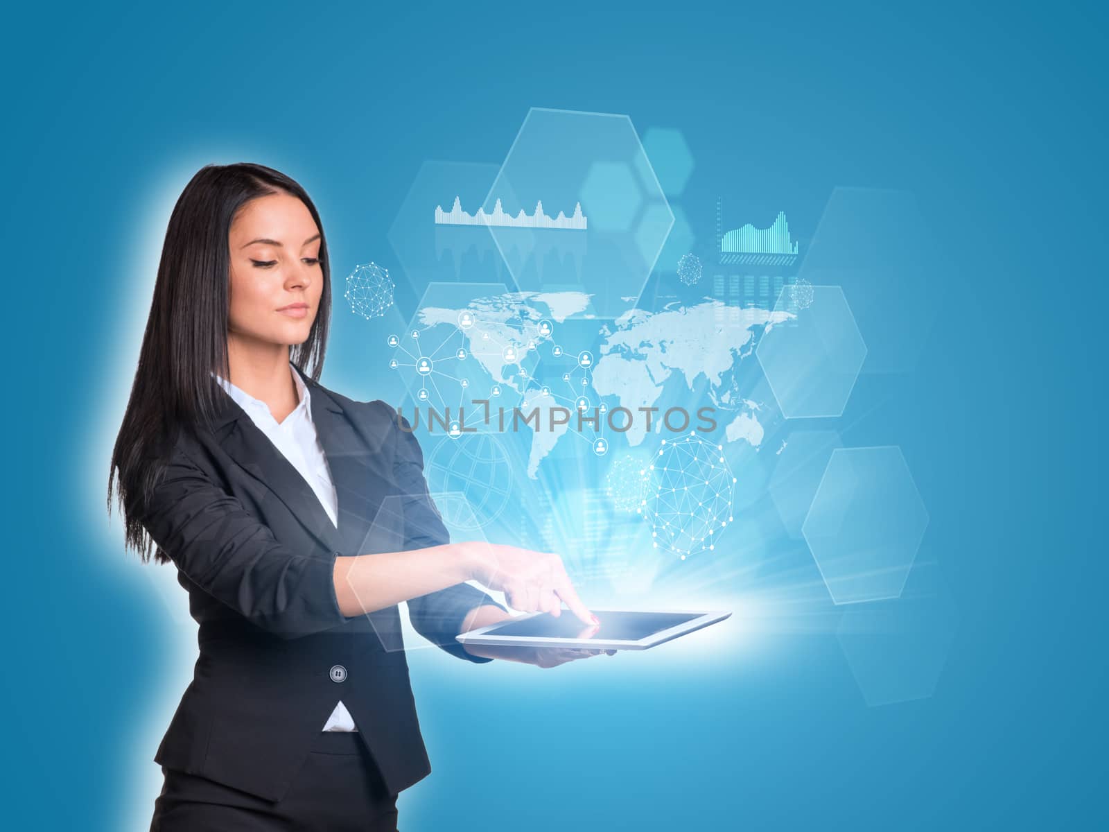 Beautiful businesswomen in suit using digital tablet. World map, transparent hexagons, graphs and network