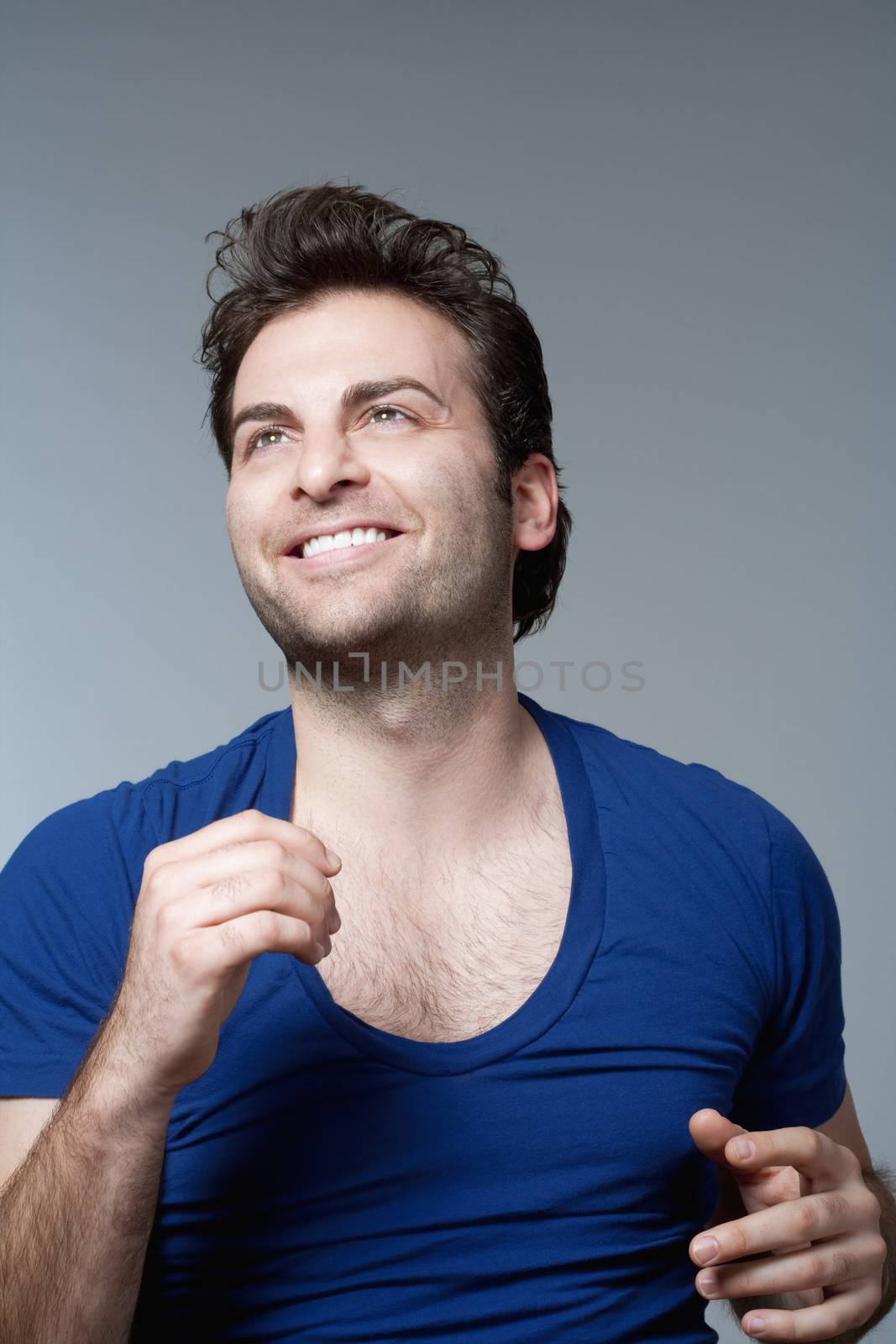 portrait of a man in blue top smiling- isolated on gray