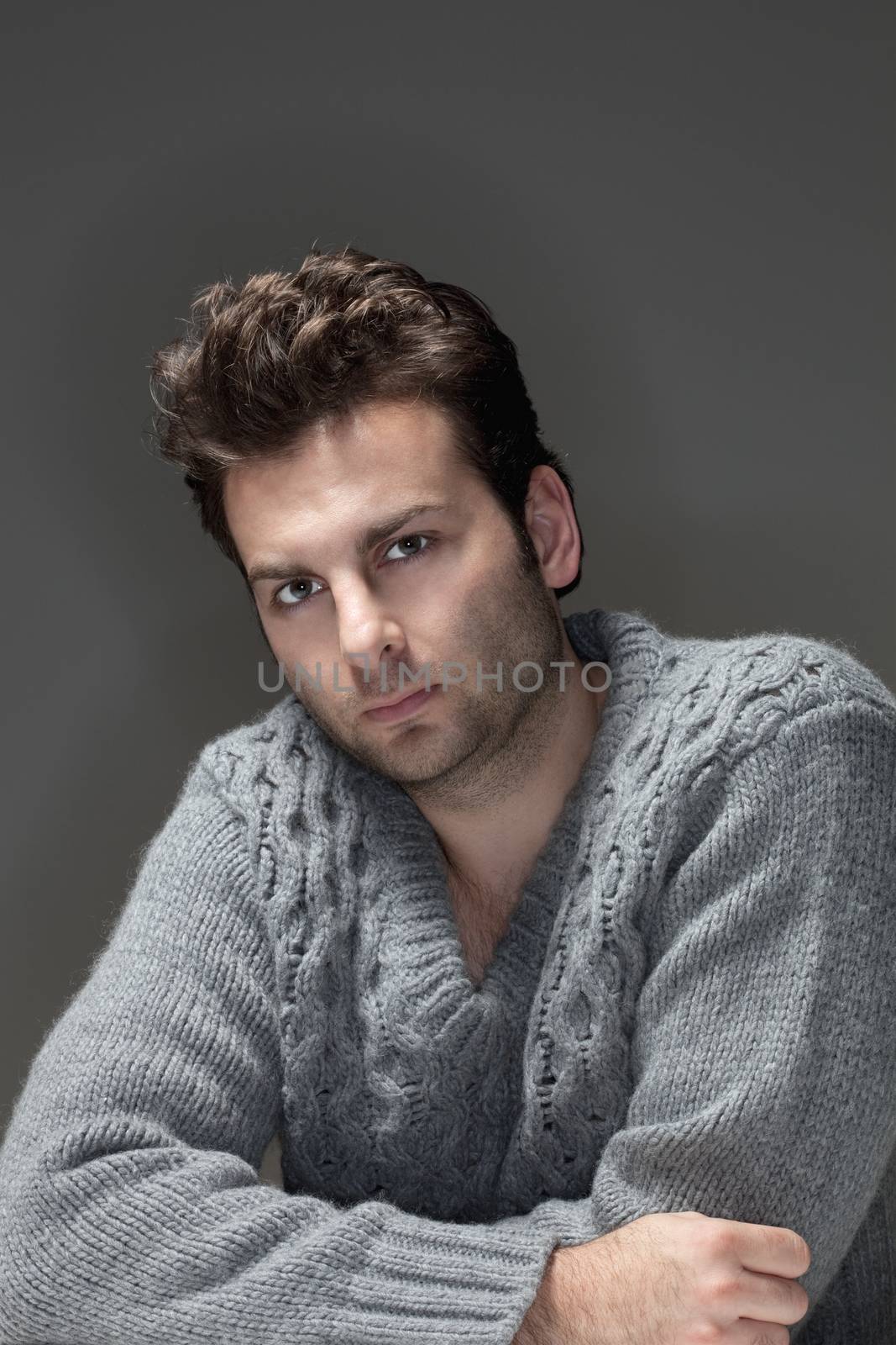 portrait of a man in a sweater looking at camera - isolated on gray