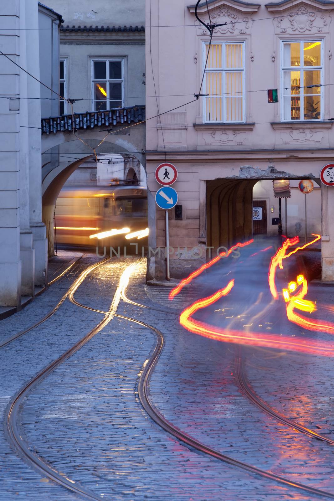 prague - cars and tramways passing under buildings at mala strana