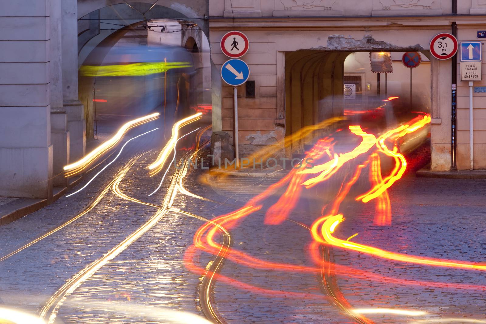 prague - cars and tramways passing under buildings at mala strana