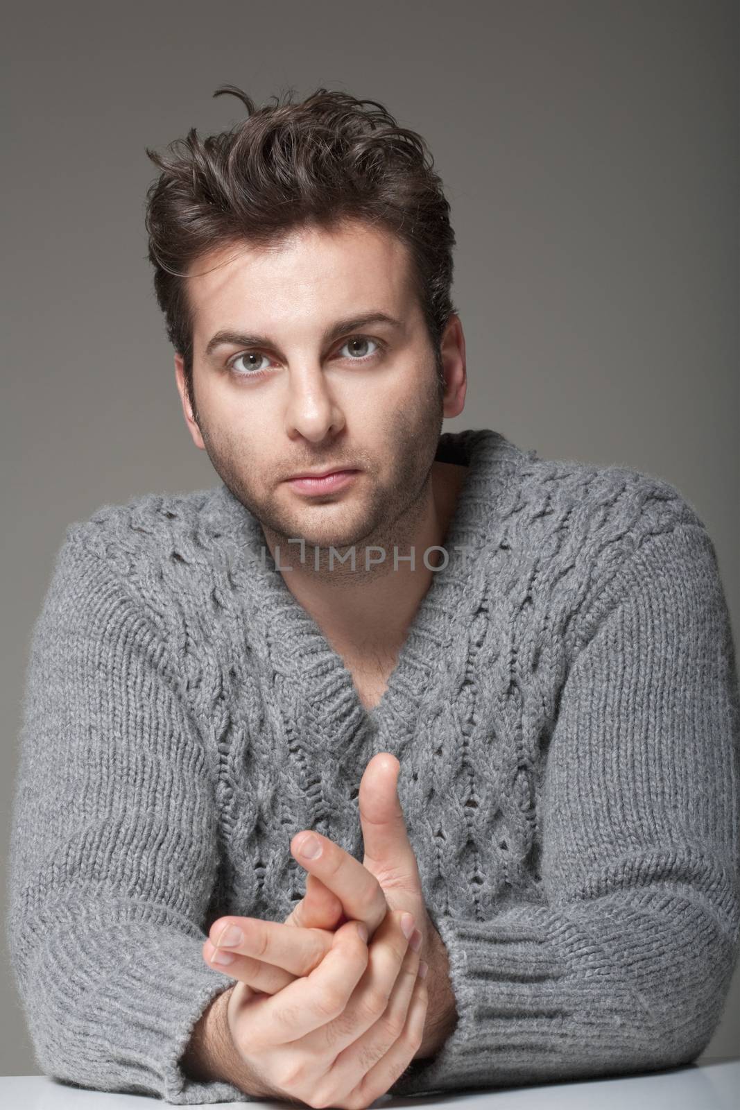 portrait of a man in a sweater looking at camera - isolated on gray