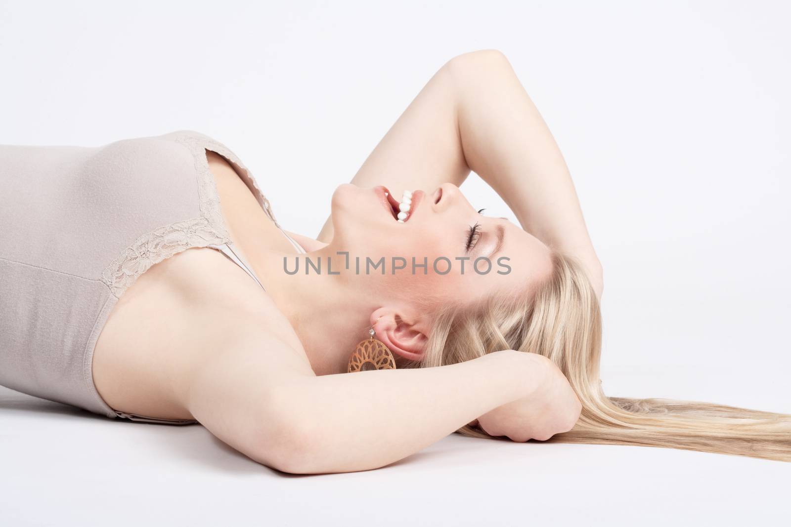 beautiful young woman lying down, eyes closed, smiling - isolated on white