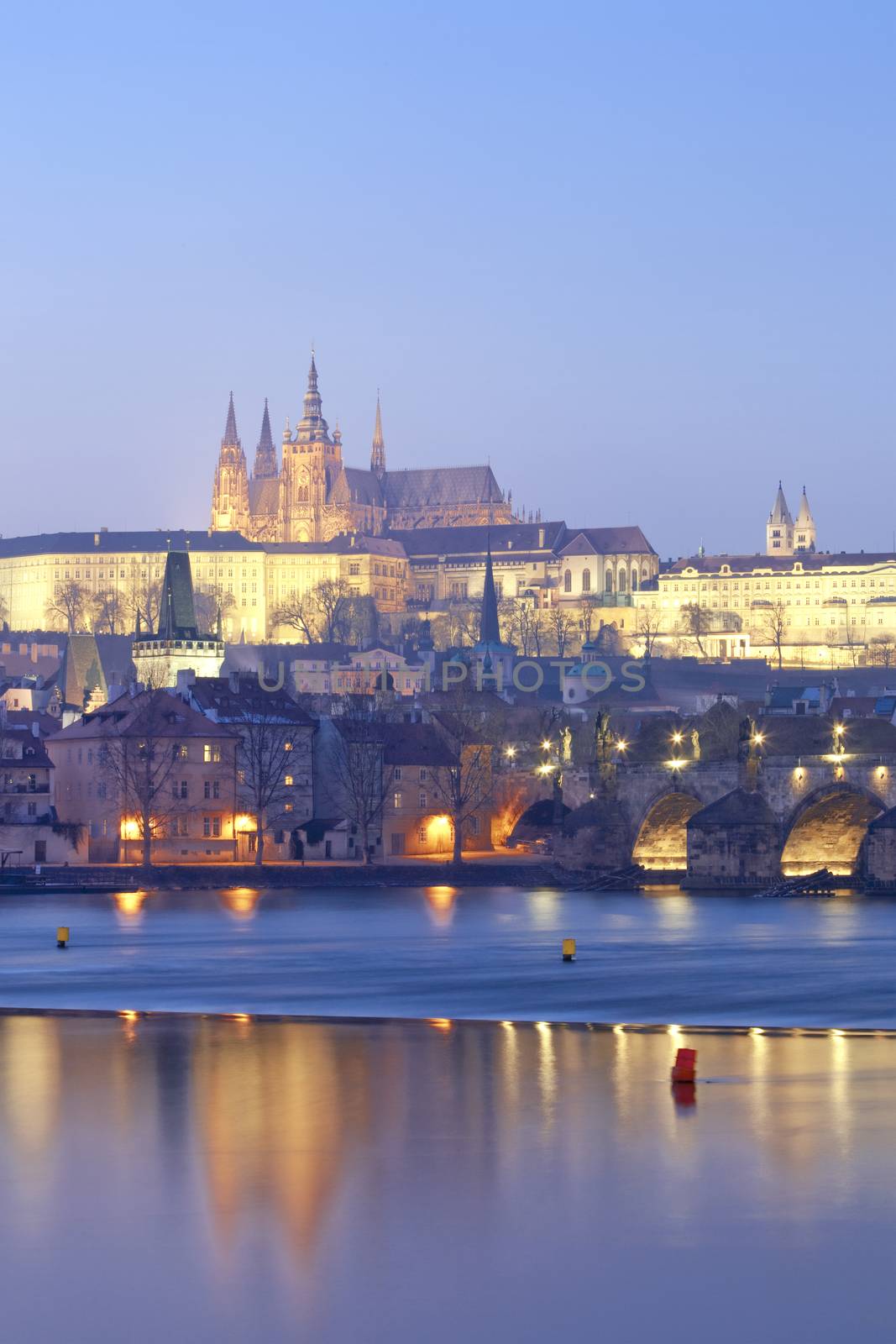 prague in winter - charles bridge and hradcany castle at dusk