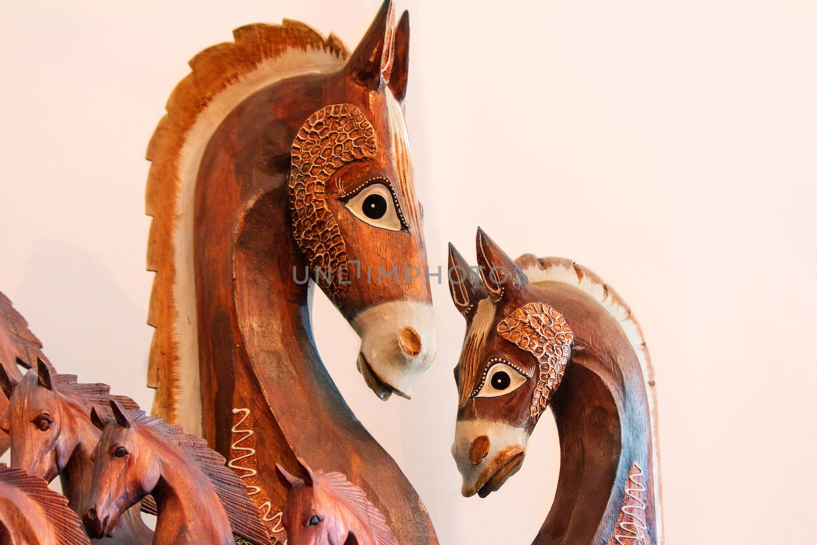 Woodcarving: original figures of horses on a light pink background.