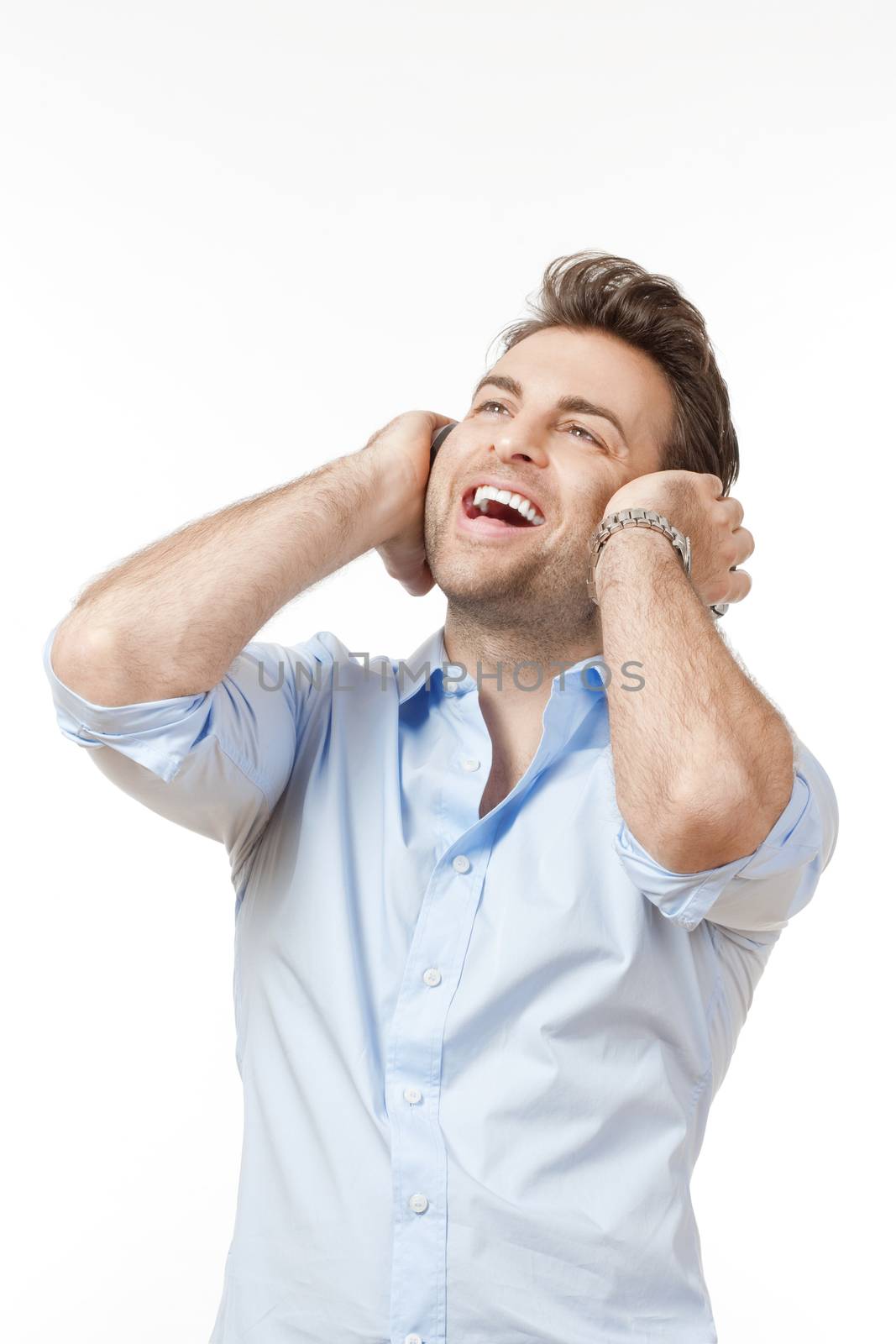 man in blue shirt with earphones listening to music - isolated on gray