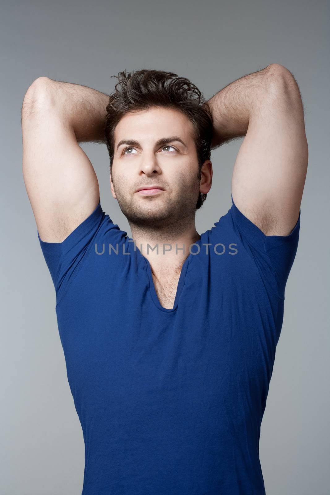 portrait of a man in blue top looking up - isolated on gray