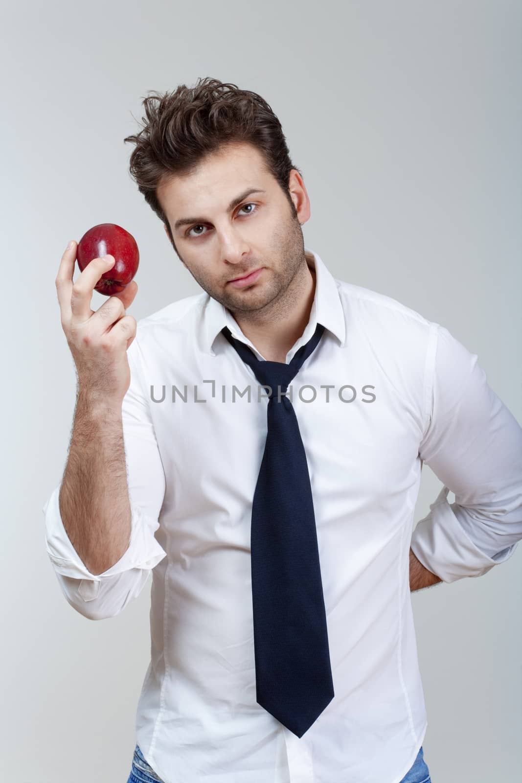 man in white shirt and tie holding red apple looking - isolated on gray