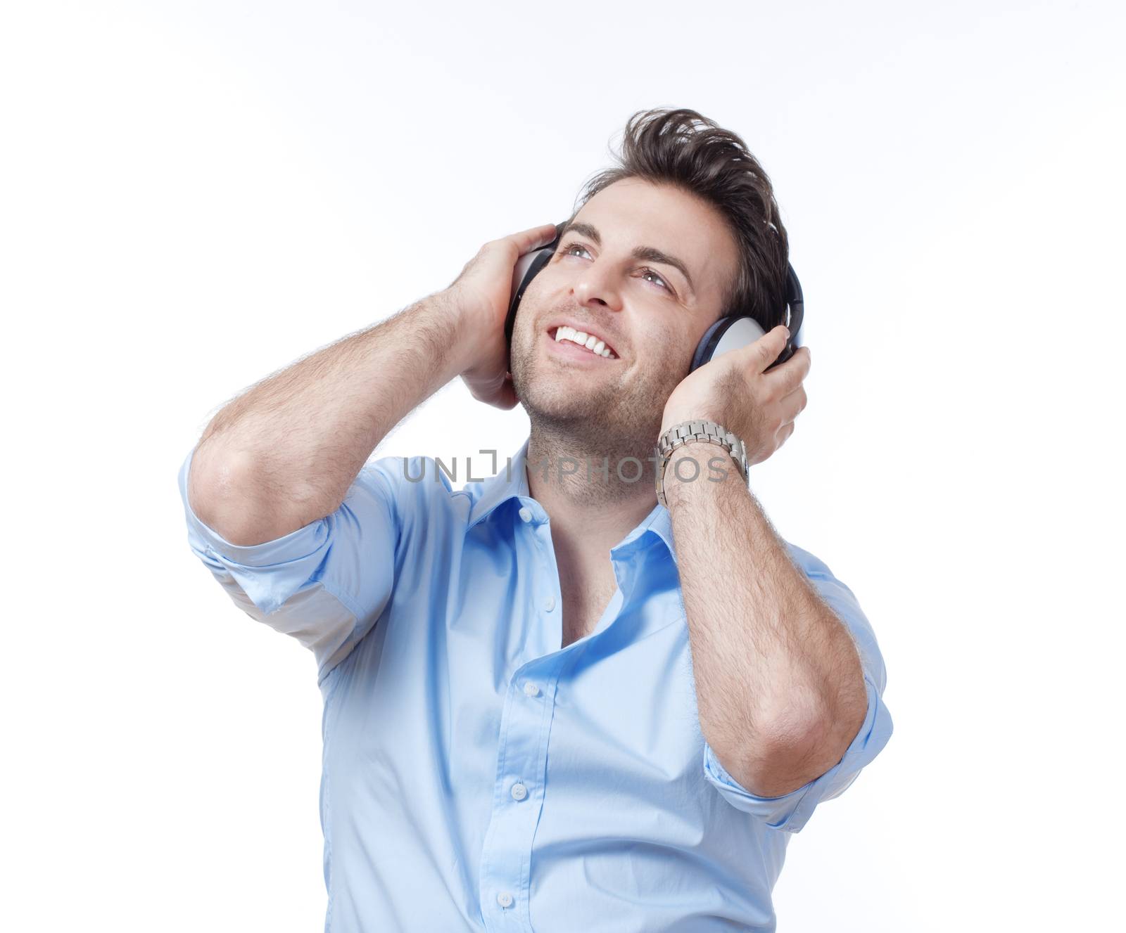 man in blue shirt with earphones listening to music - isolated on gray