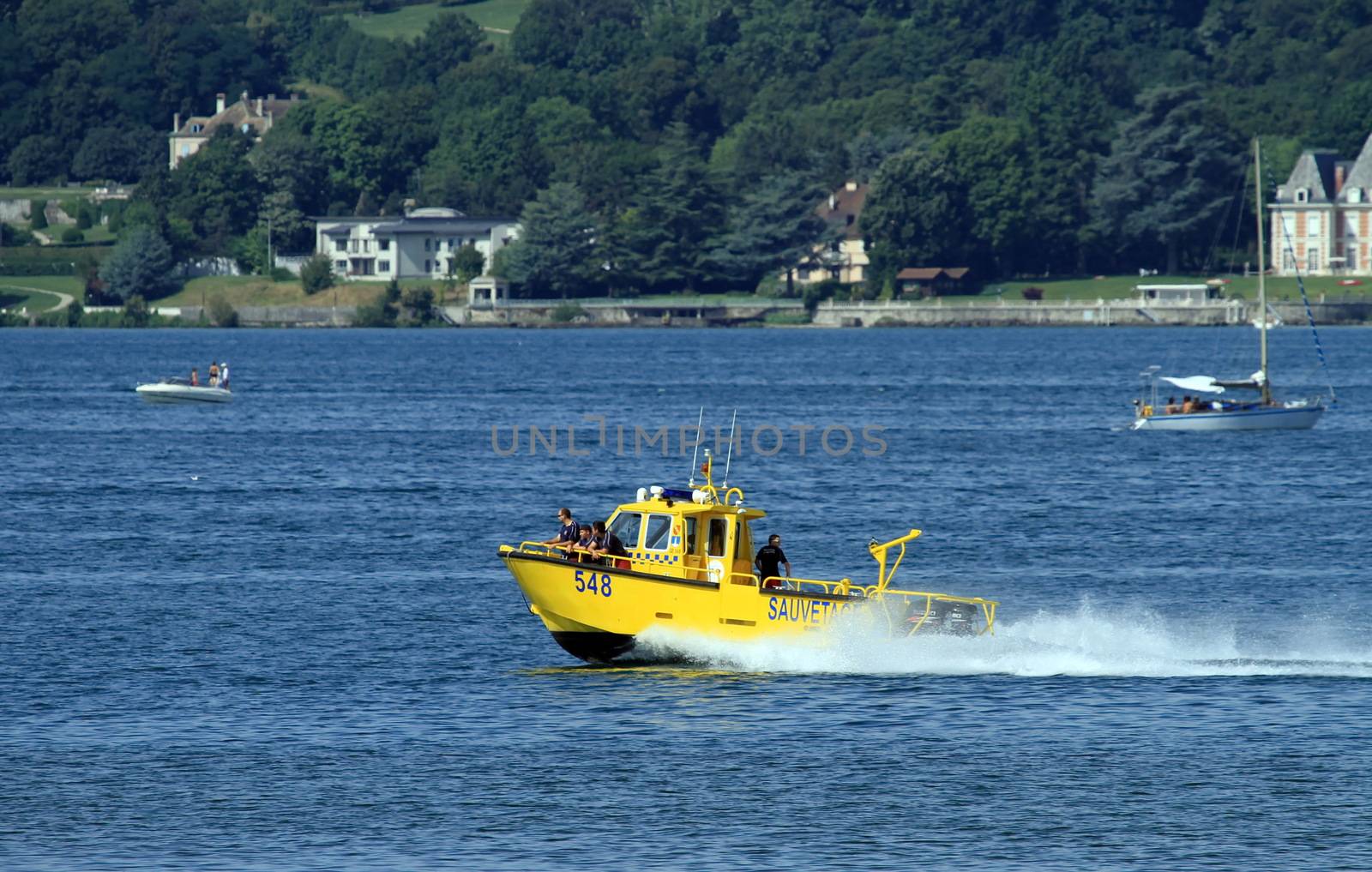 men into rescue boat on the lake in Neuchatel, Switzerland by Elenaphotos21