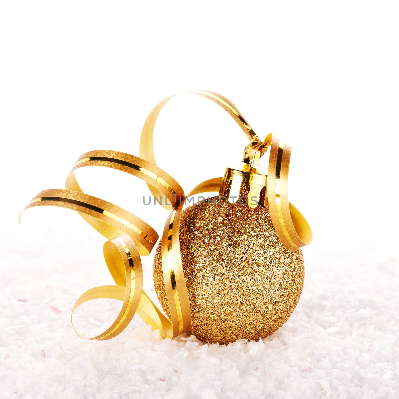 New Year's golden ball on snow with a tape. New Year's golden balls. Christmas balls. Christmas tree decorations. Christmas jewelry.