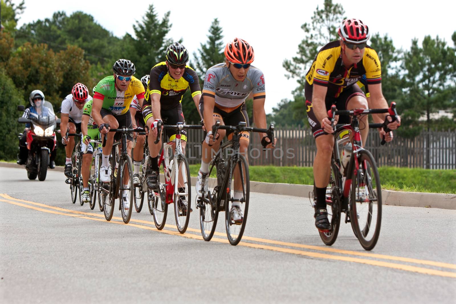 Duluth, GA, USA - August 2, 2014:  Cyclists bunched together in a pack race through a straightaway in the Georgia Cup, a criterium event held on the streets of downtown Duluth.