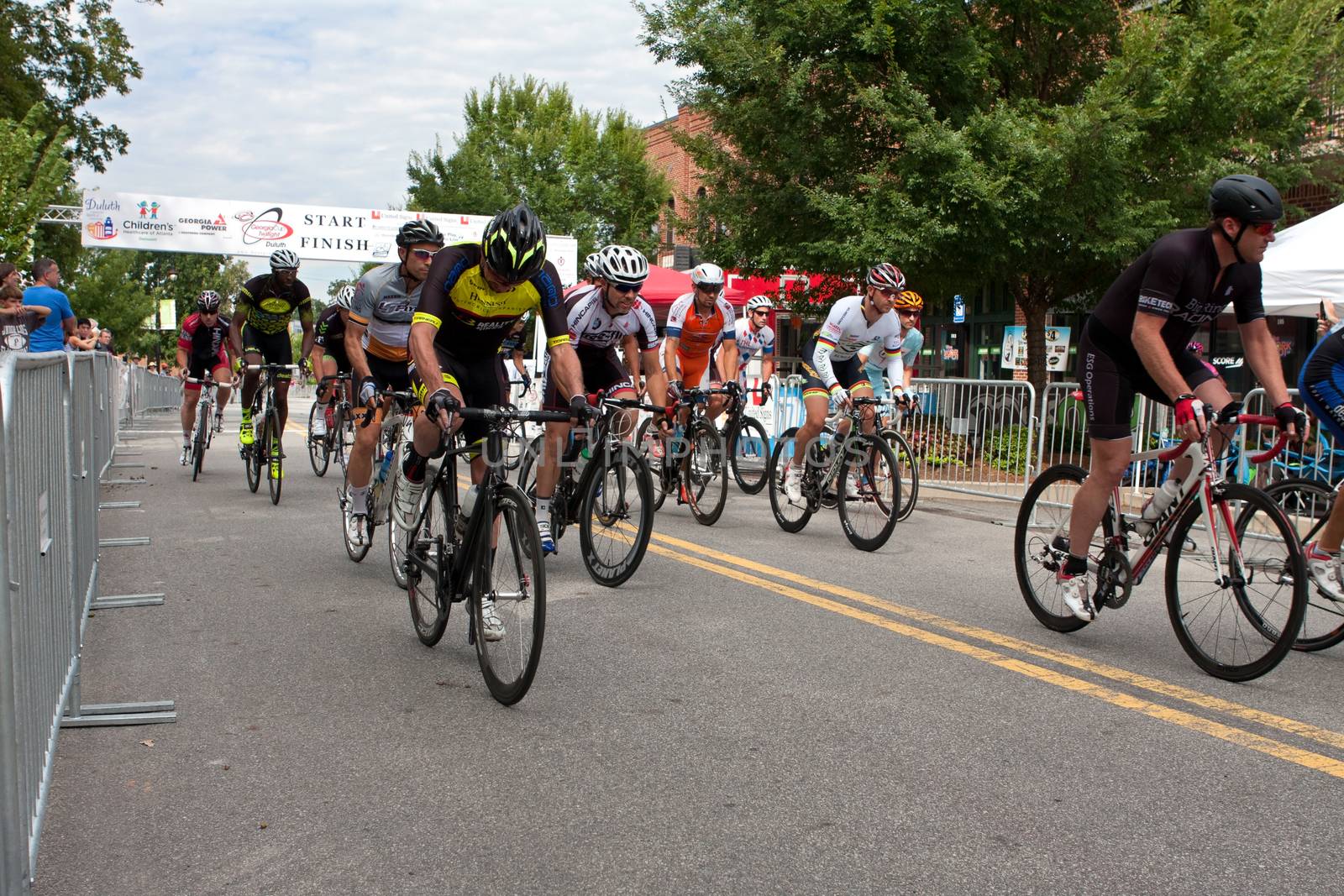 Duluth, GA, USA - August 2, 2014:  A group of cyclists sprint from the starting line as they compete in the Georgia Cup Criterium event.