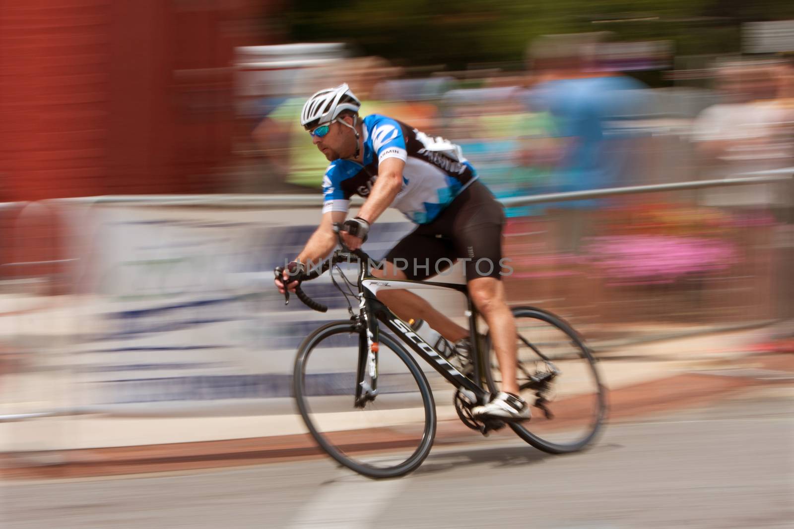 Duluth, GA, USA - August 2, 2014:  Motion blur pan of an amateur cyclist going into a turn while competing in the Georgia Cup Criterium in downtown Duluth. 