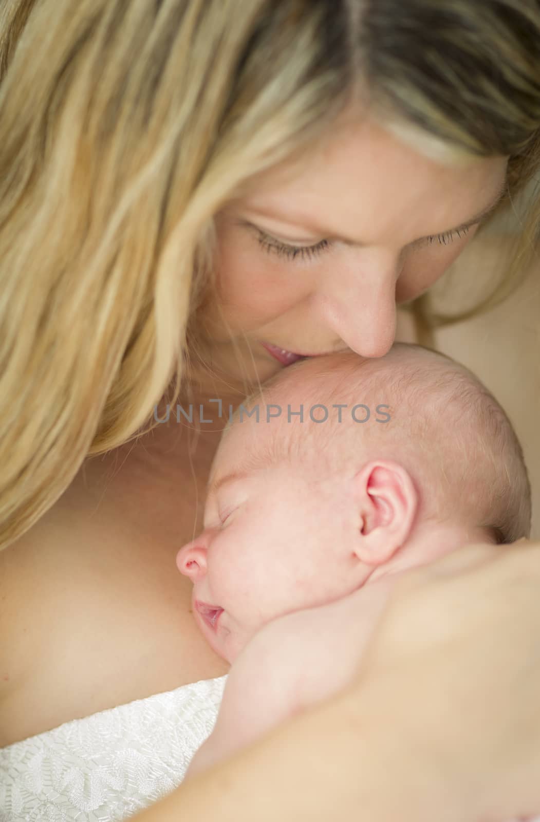 Young Caucasian Beautiful Mother Holding Her Precious Newborn Baby Girl.