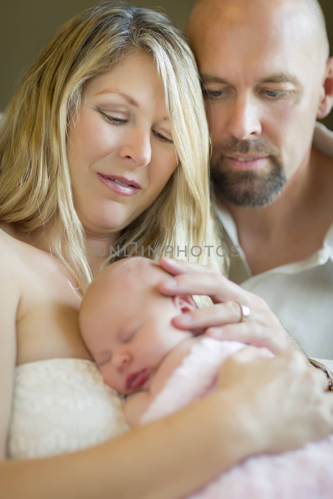 Beautiful Young Couple Holding Their Newborn Sleeping Baby Girl Inside.