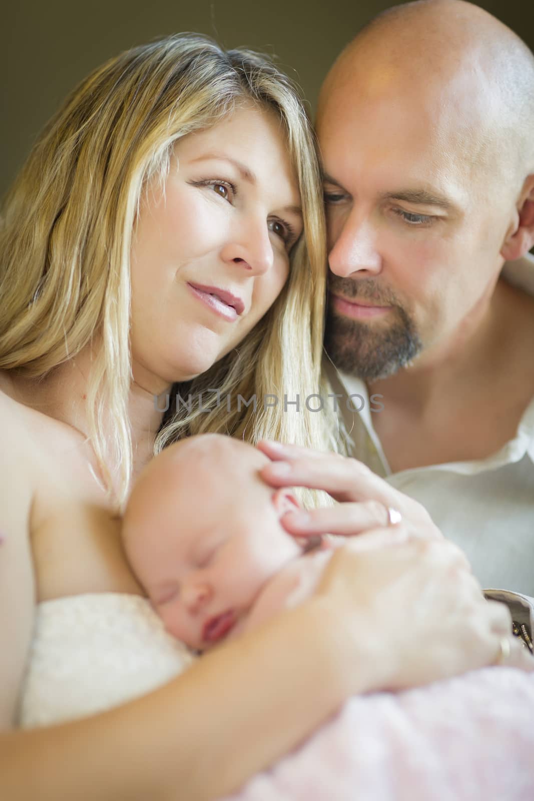 Beautiful Young Couple Holding Their Newborn Sleeping Baby Girl Inside.