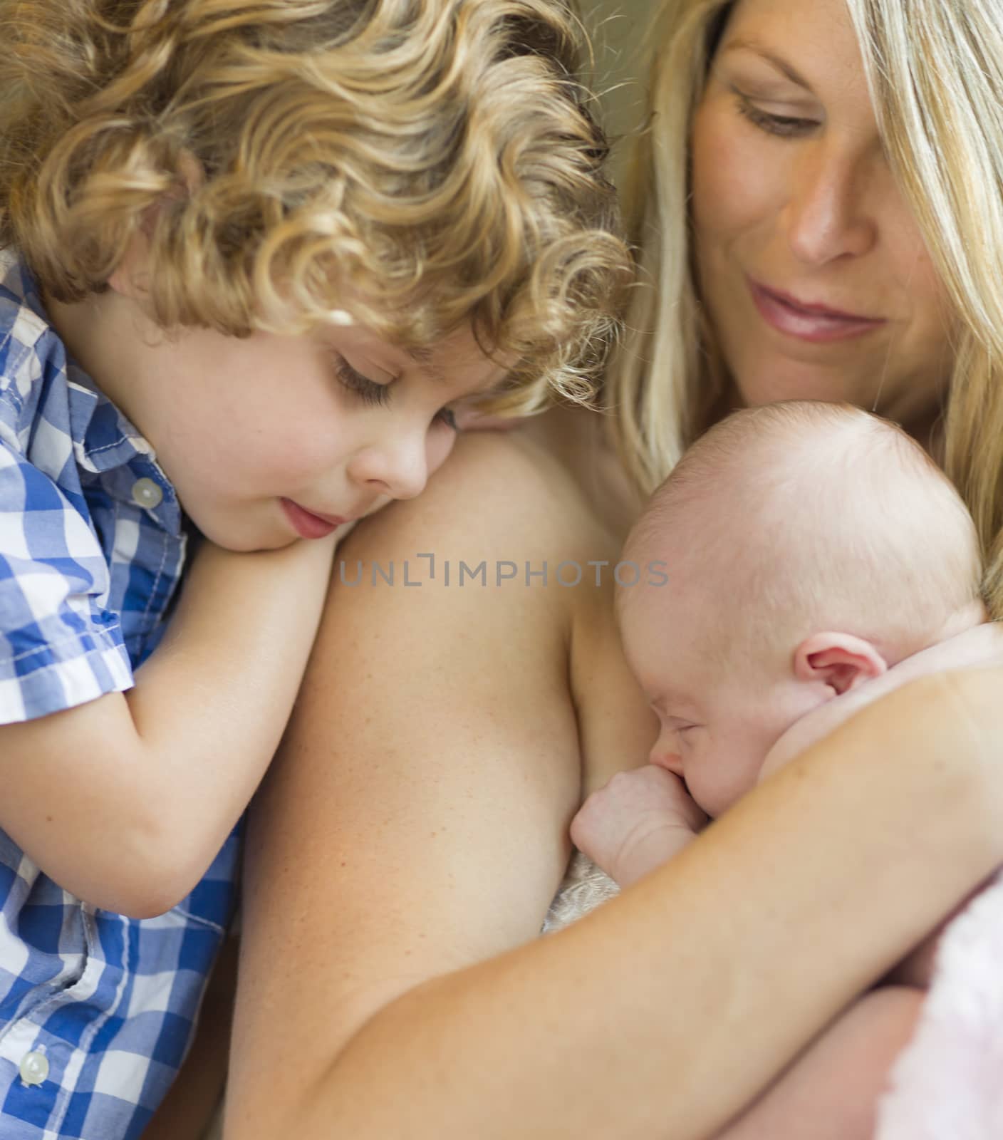 Beautiful Young Mother Holds Precious Newborn Baby Girl as Brother Looks On.