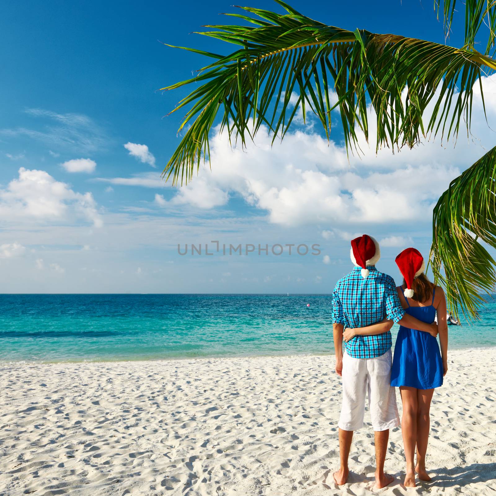 Couple in blue clothes on a beach at christmas by haveseen