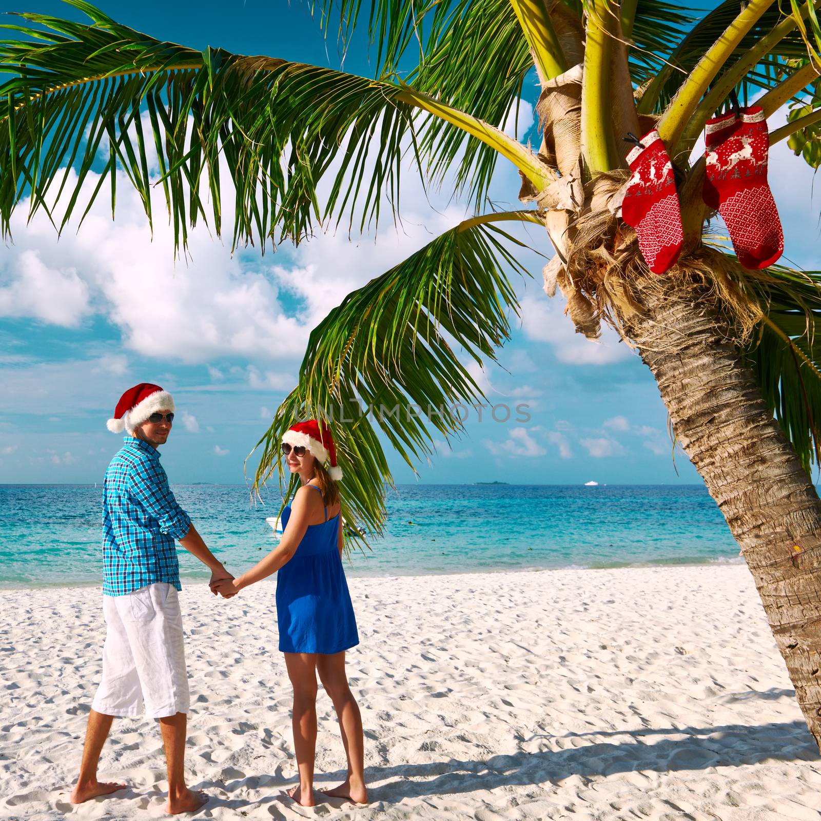 Couple in blue clothes on a beach at christmas by haveseen