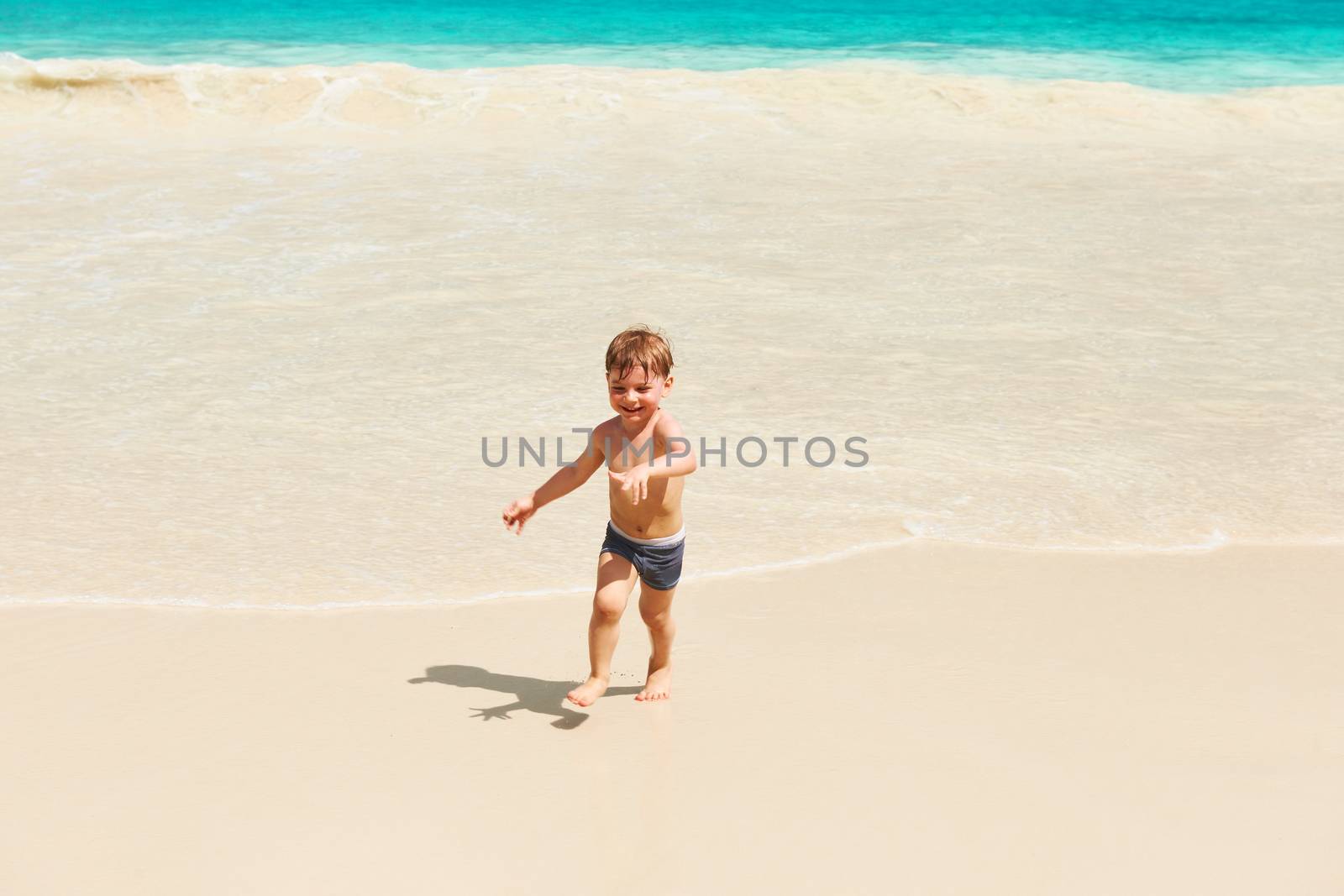 Two year old boy playing on beach by haveseen