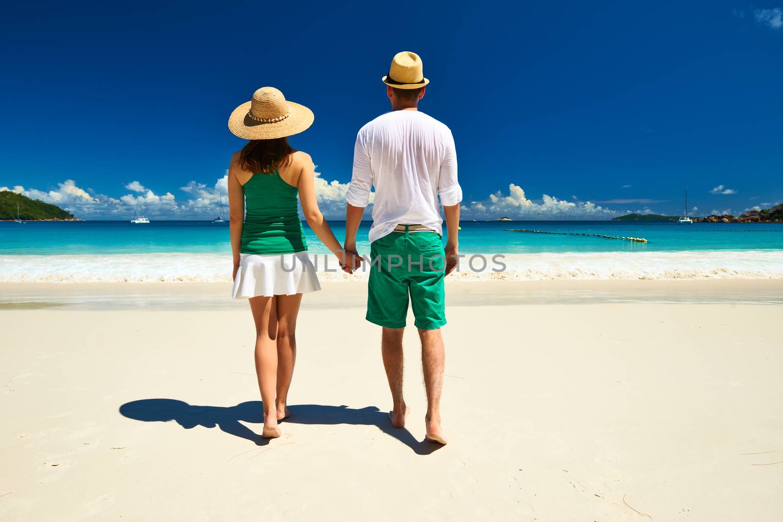 Couple in green on a tropical beach at Seychelles