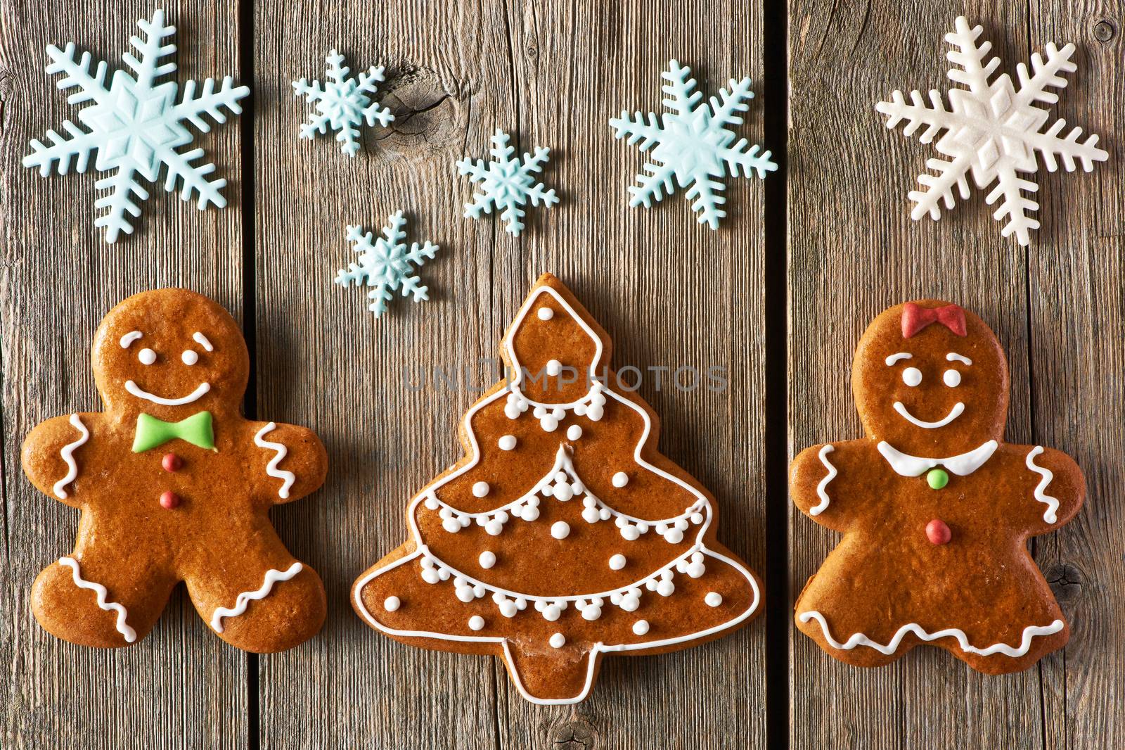 Christmas homemade gingerbread couple and tree on wooden table