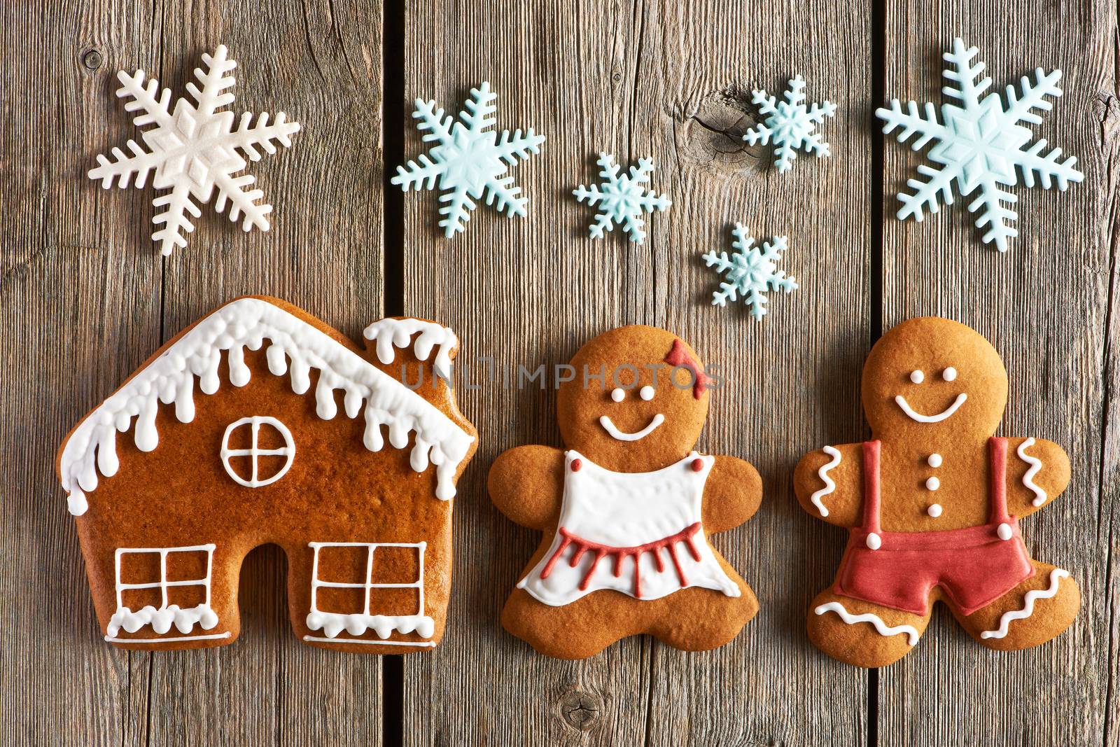 Christmas homemade gingerbread couple and house on wooden table