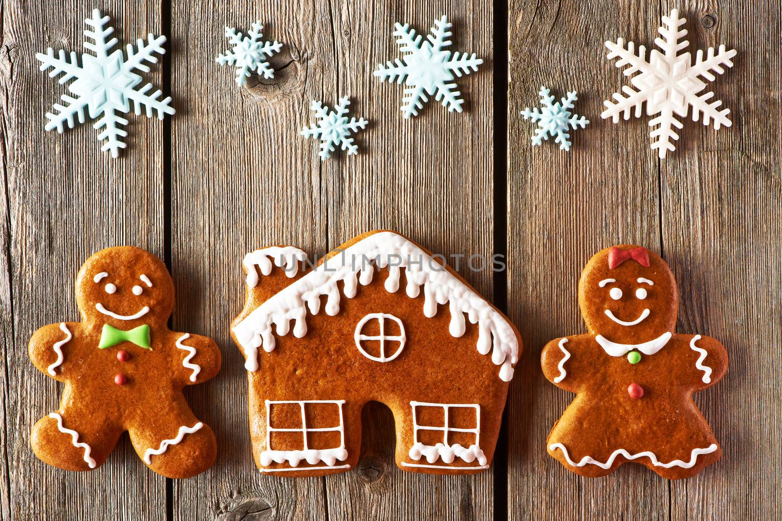 Christmas homemade gingerbread couple and house on wooden table