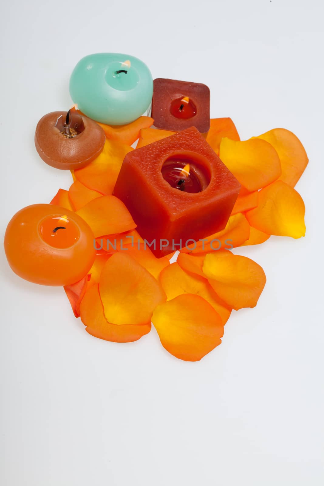 Spilt petals of the orange-rose around the aromatic candle by wjarek