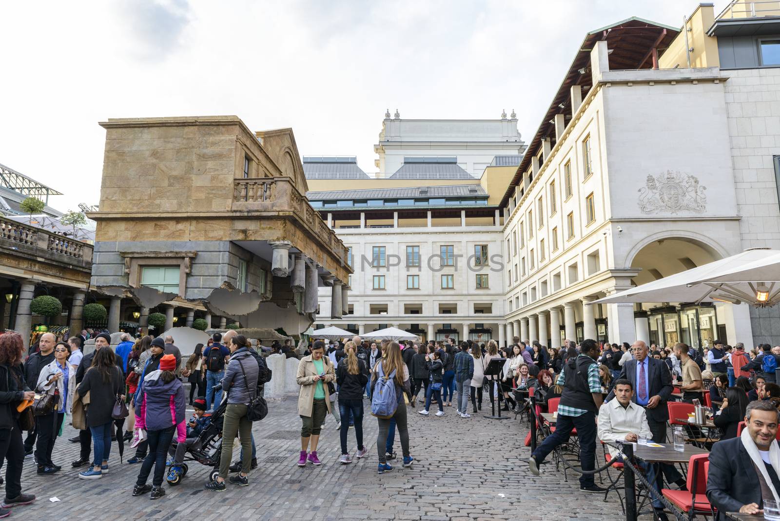 LONDON, UK - OCTOBER 05: Tourist observing artwork by artist Alex Chinneck in Covent Garden. The floating piazza will remain there until the end of the month. October 05, 2014 in London.