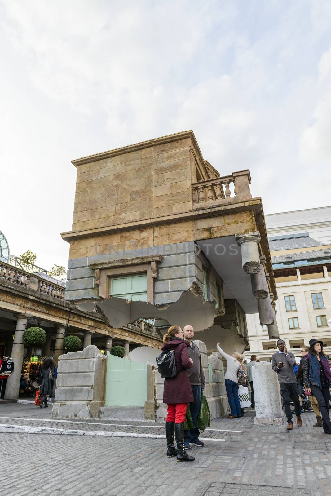 LONDON, UK - OCTOBER 05: Tourist observing artwork by artist Alex Chinneck in Covent Garden. The floating piazza will remain there until the end of the month. October 05, 2014 in London.