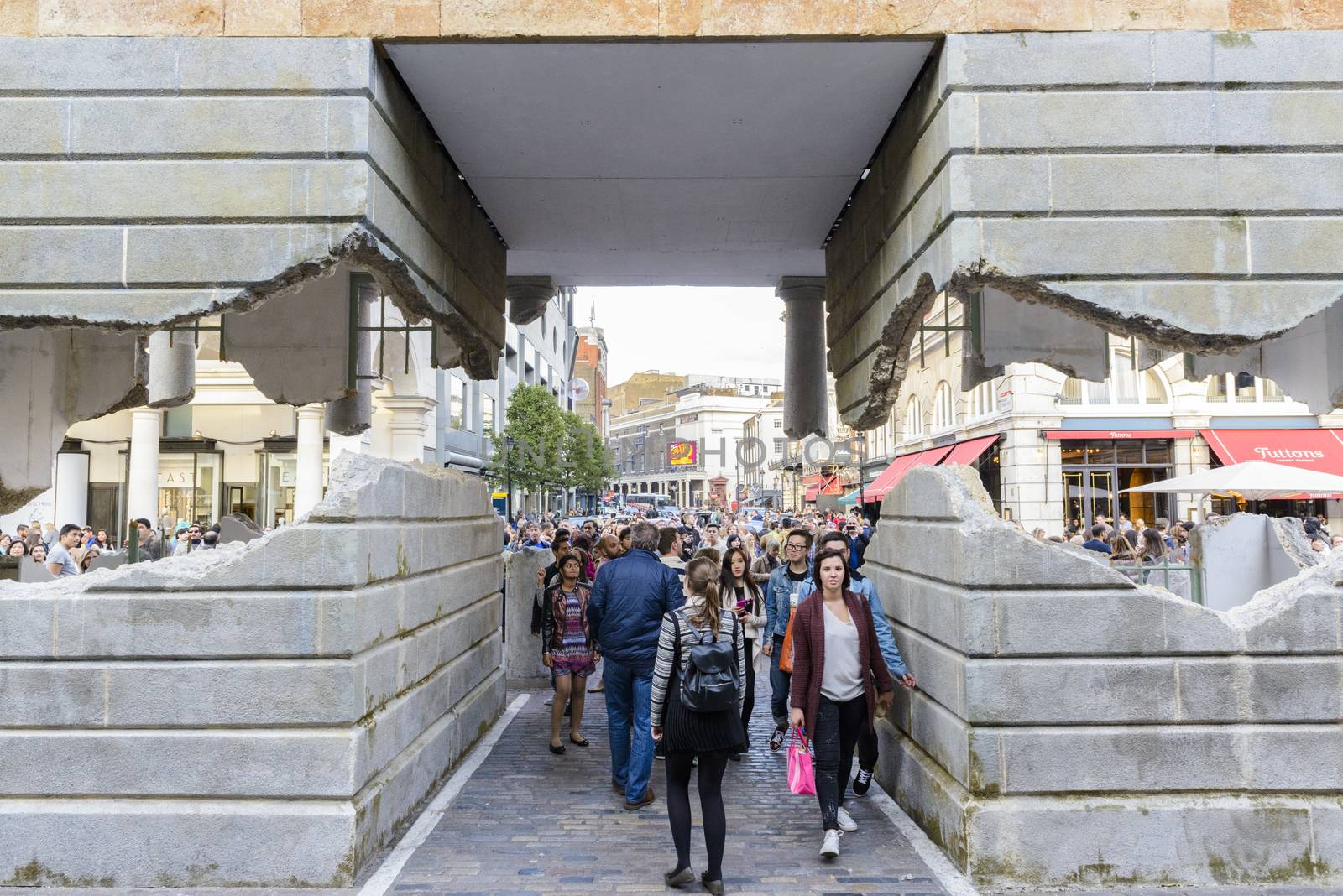LONDON, UK - OCTOBER 05: Tourist observing artwork by artist Alex Chinneck in Covent Garden. The floating piazza will remain there until the end of the month. October 05, 2014 in London.