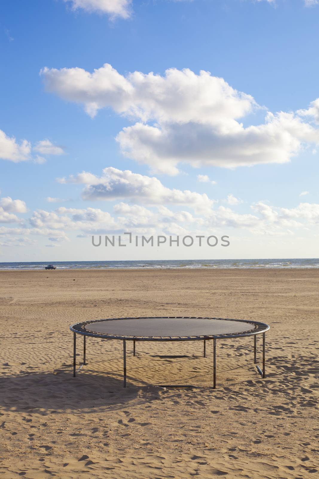 Empty trampoline at beach with blue sky