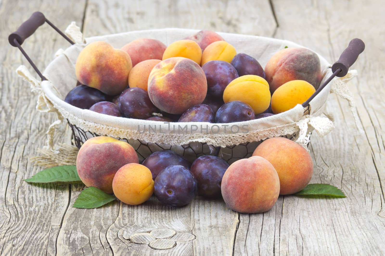 fresh fruits in a basket on wooden background