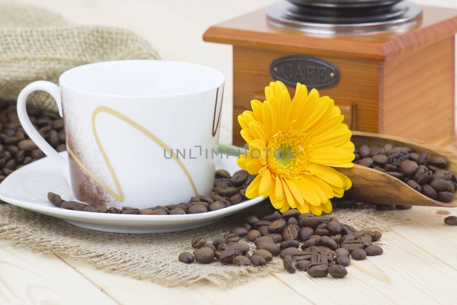 cup of coffee with yellow gerbera and coffee beans