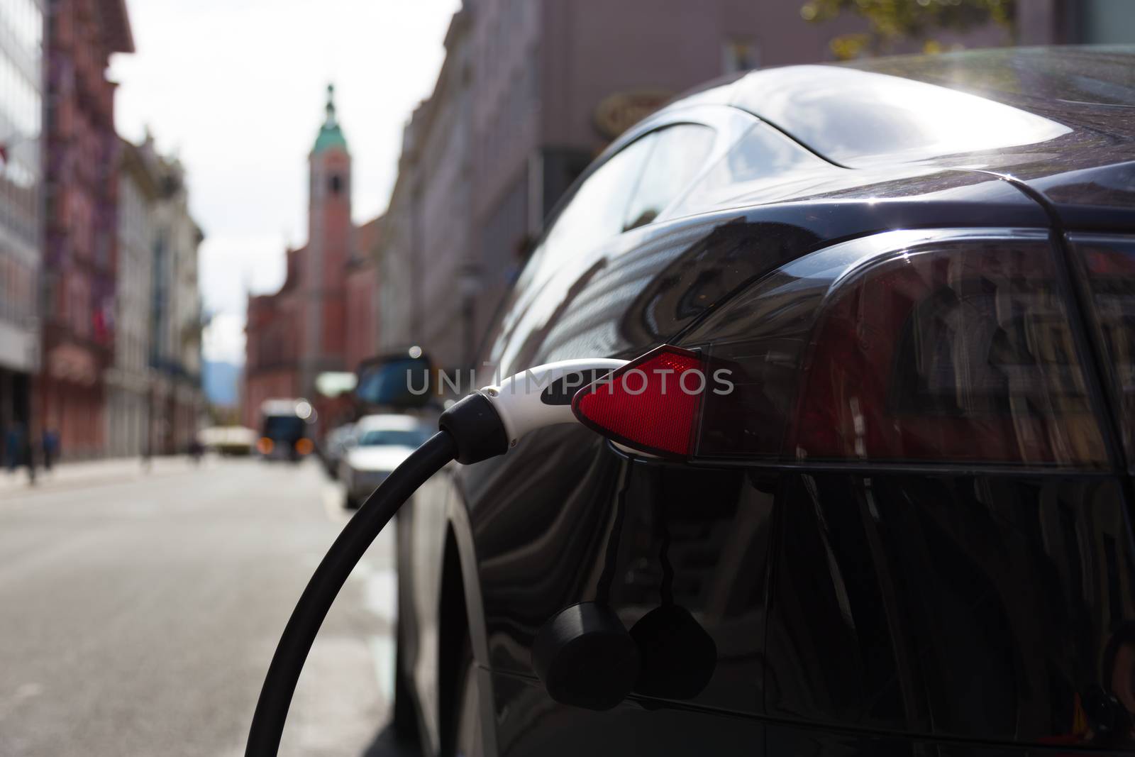 Power supply for electric car charging.  Electric car charging station. Close up of the power supply plugged into an electric car being charged.