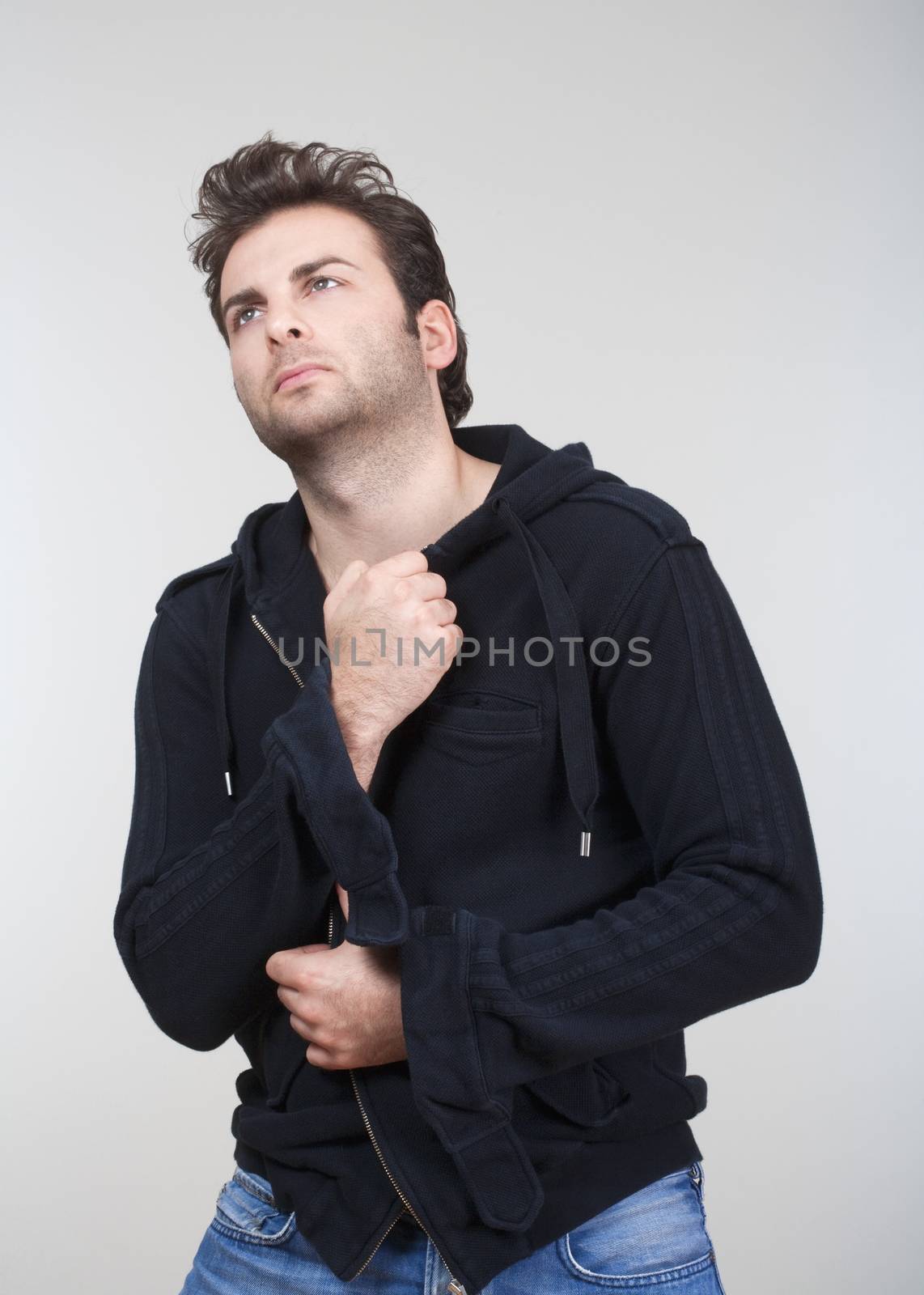 portrait of man in black sweater looking up - isolated on gray