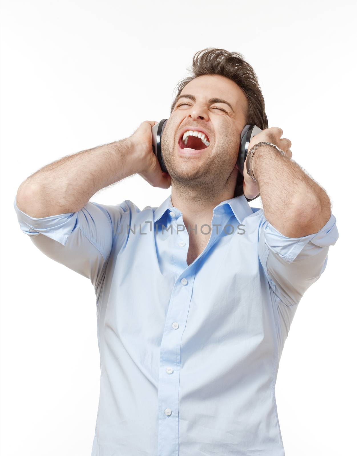 man in blue shirt with earphones listening to music - isolated on white