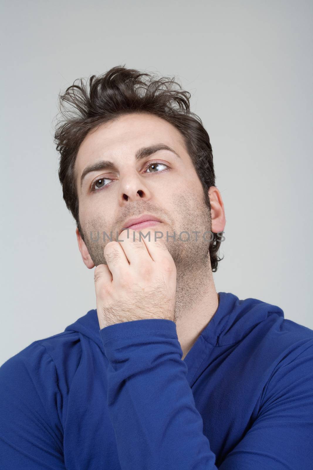 portrait of a man in blue top looking up - isolated on gray