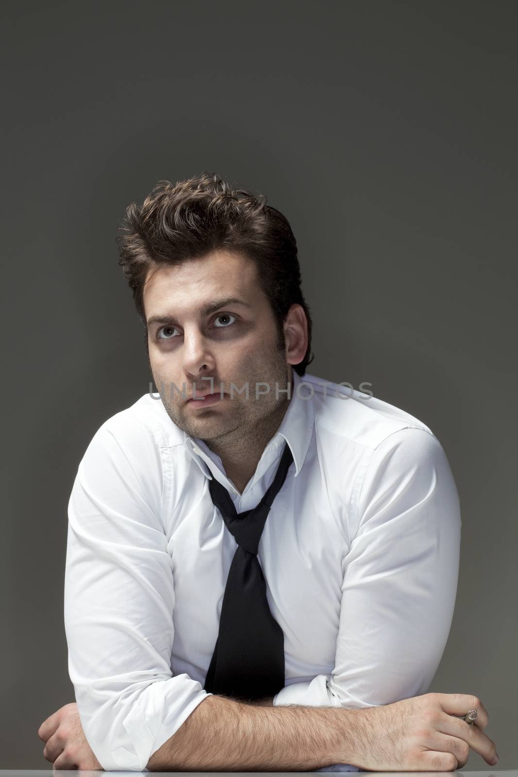 man in white shirt looking up, thinking - isolated on gray